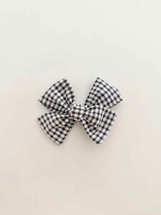 Black and white checkered bow on a beige background