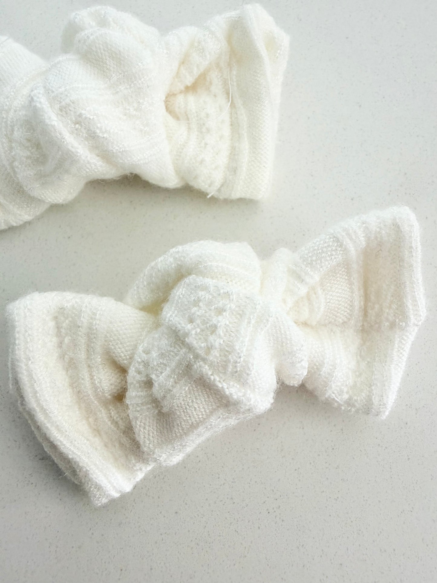 Ivory knit toddler pigtail bows, handmade in two sizes for a soft, cozy, and classic everyday look.