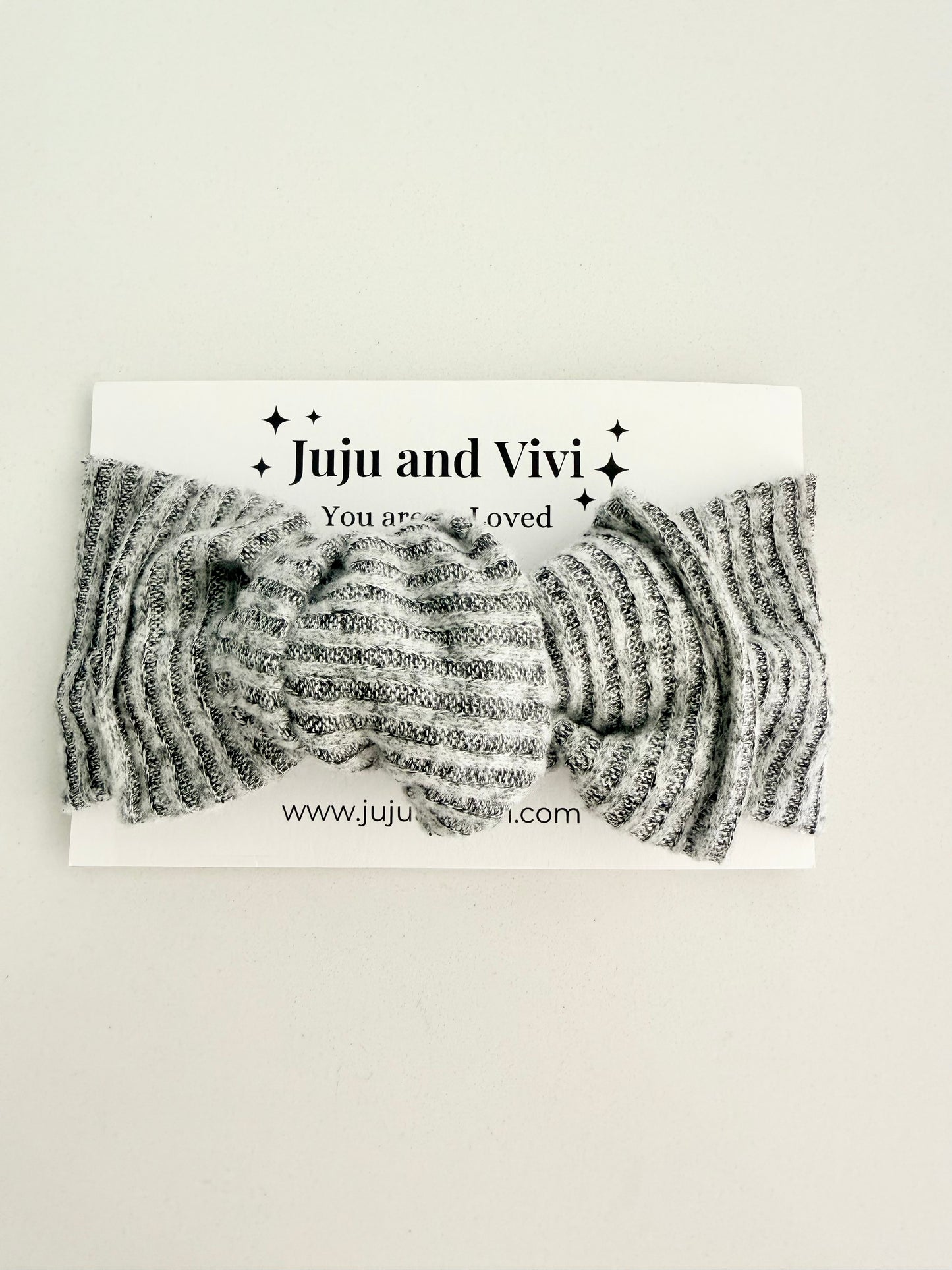 Grey jersey knit baby head wrap with subtle striped texture, stretchy fit, displayed on a white background.