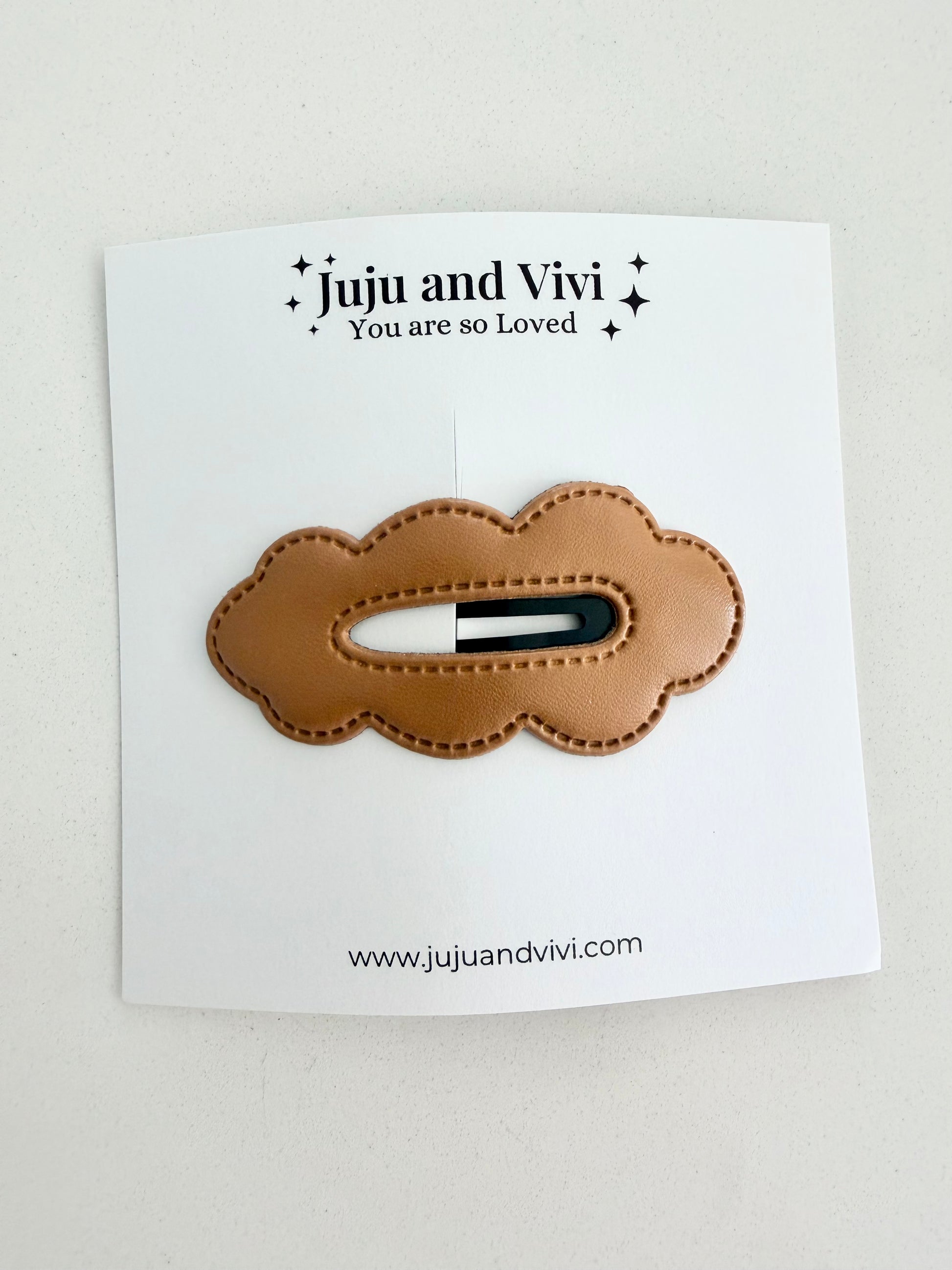Brown leather hair clip on a white card with 'Juju and Vivi' branding.