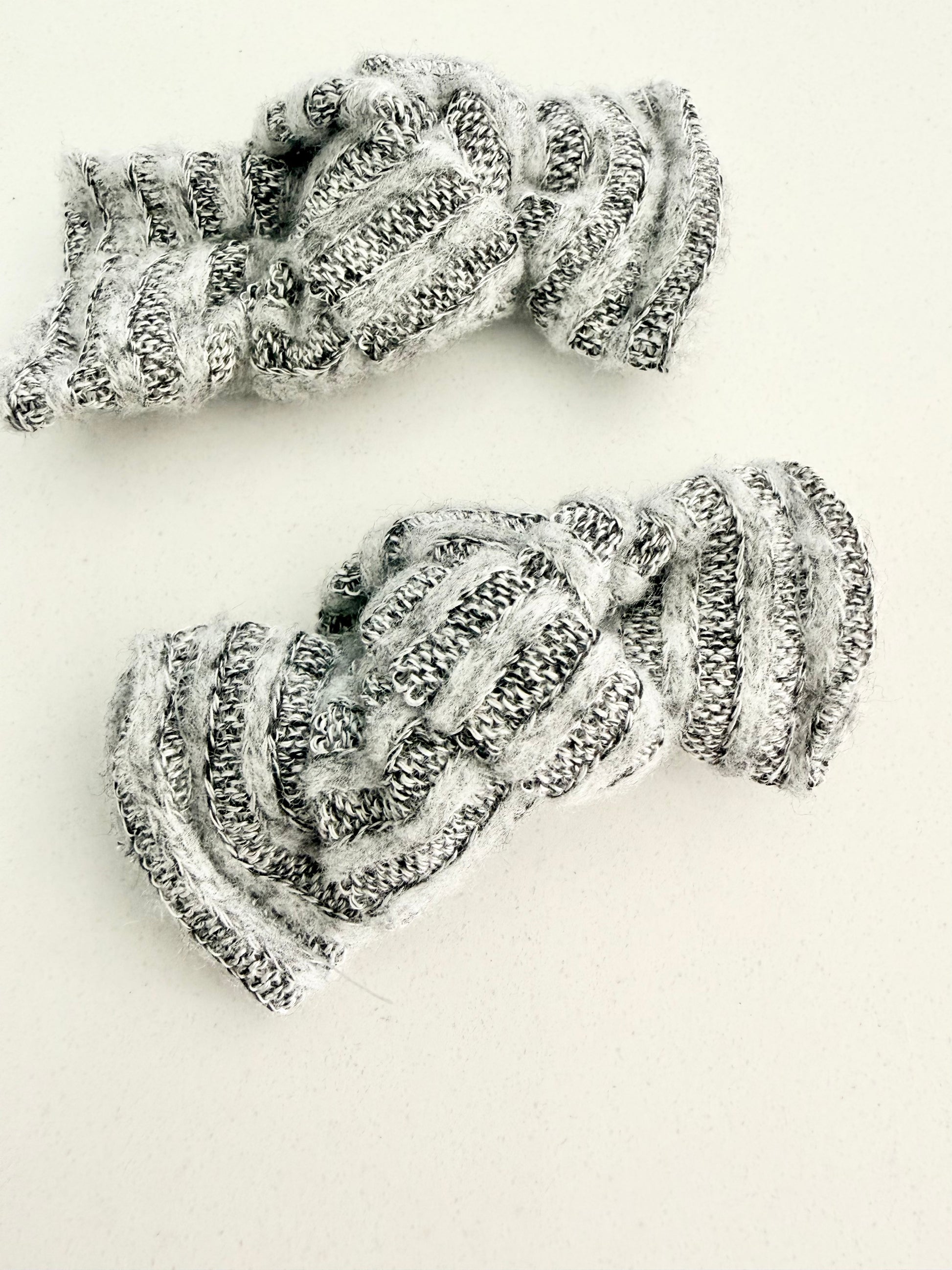 Gray and white knit toddler pigtail bows in two sizes, handmade for a soft, cozy everyday look.
