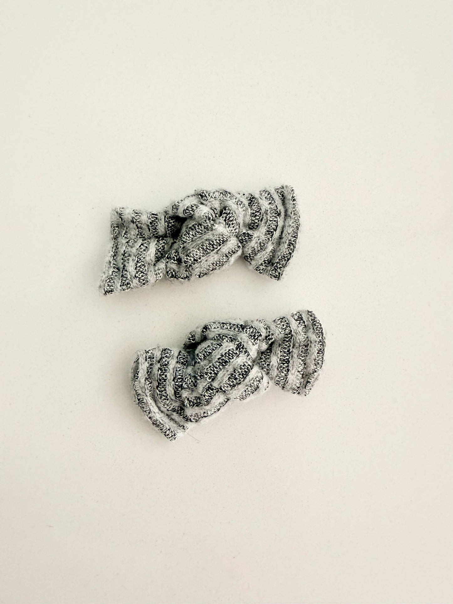 Gray and white knit toddler pigtail bows in two sizes, handmade for a soft, cozy everyday look.
