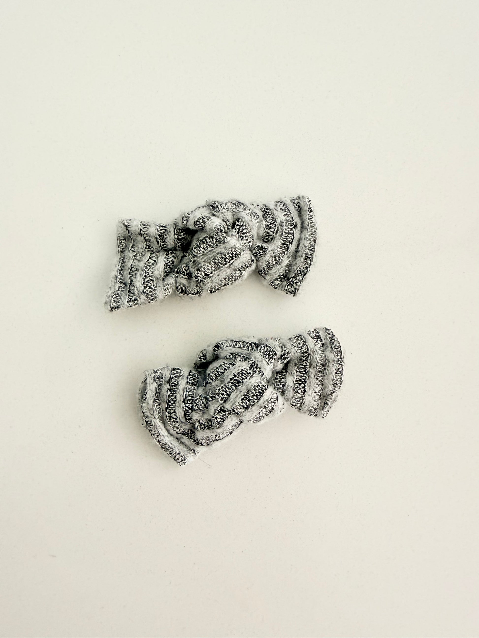 Gray and white knit toddler pigtail bows in two sizes, handmade for a soft, cozy everyday look.
