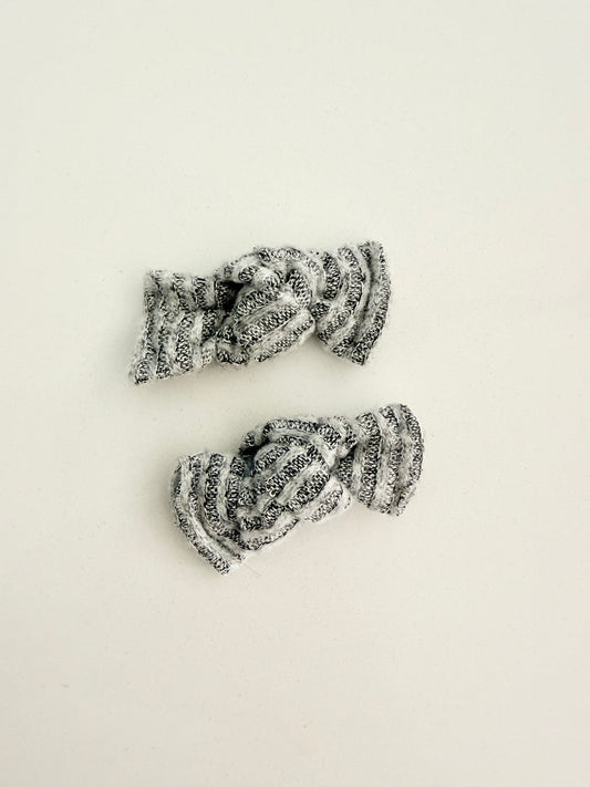 Gray and white knit toddler pigtail bows in two sizes, handmade for a soft, cozy everyday look.
