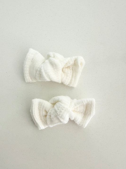 Ivory knit toddler pigtail bows, handmade in two sizes for a soft, cozy, and classic everyday look.