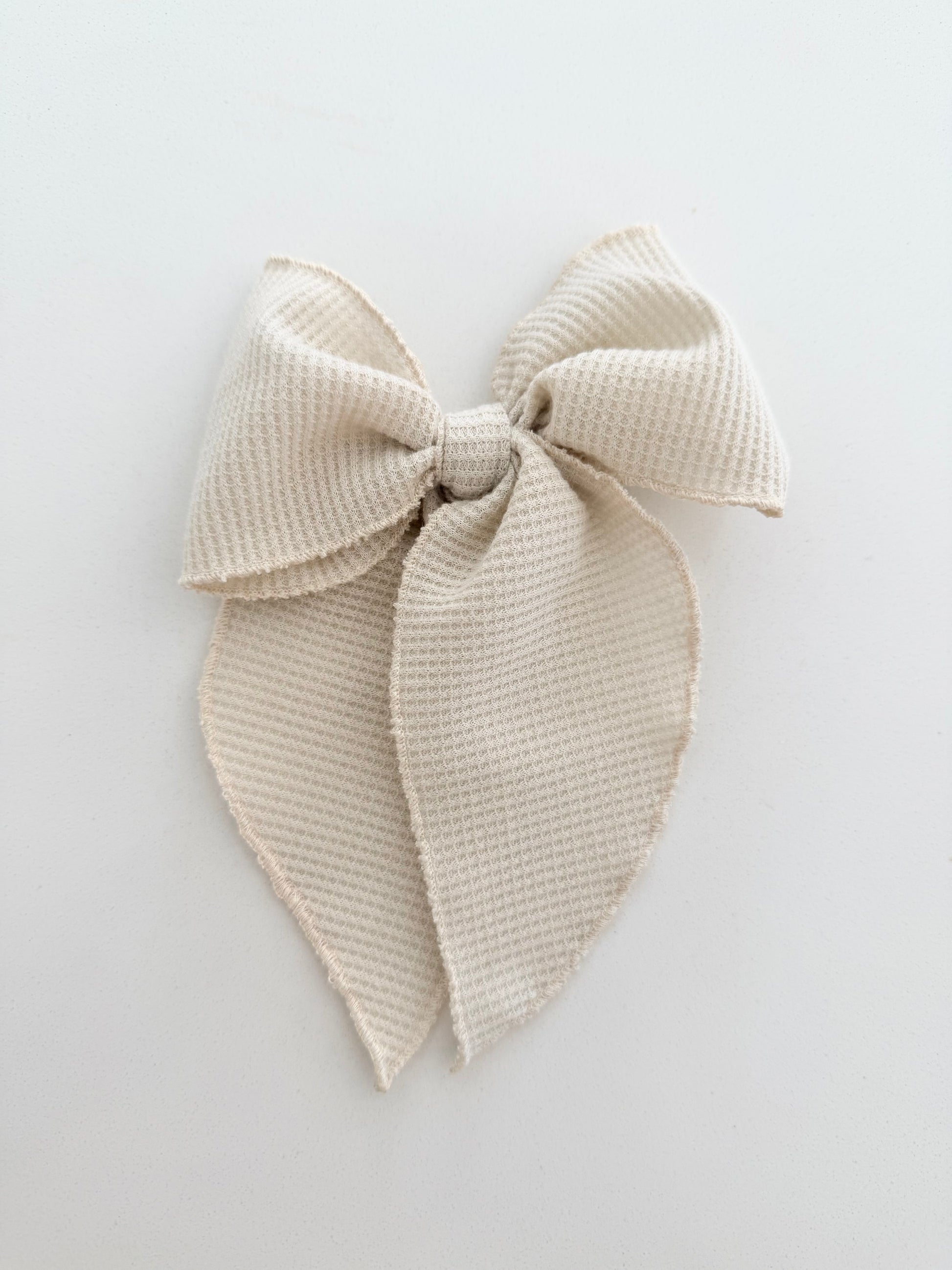 Midi Beige textured waffle bow on a light gray background