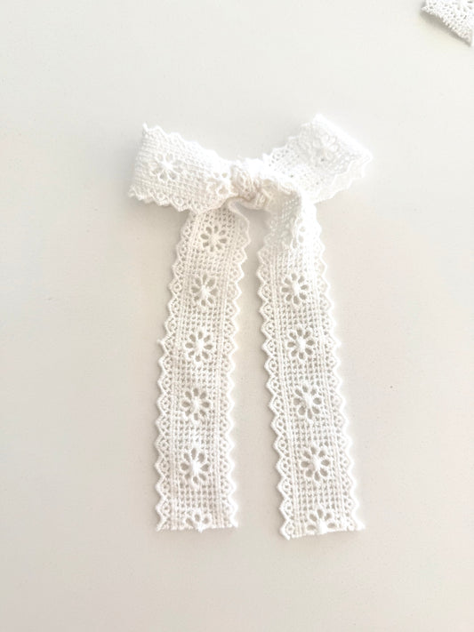 Ivory lace long tail and mid tail bows with floral embroidery on alligator clips, displayed flat for detail.