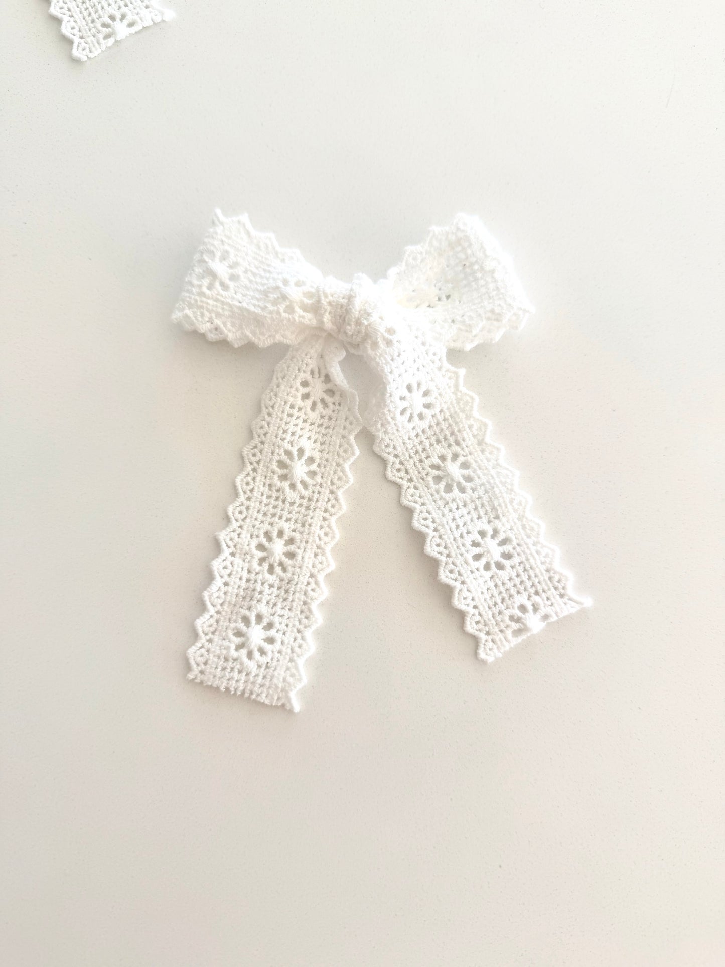 Ivory lace long tail and mid tail bows with floral embroidery on alligator clips, displayed flat for detail.
