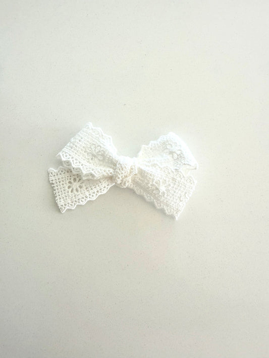 White lace bow on a light gray background