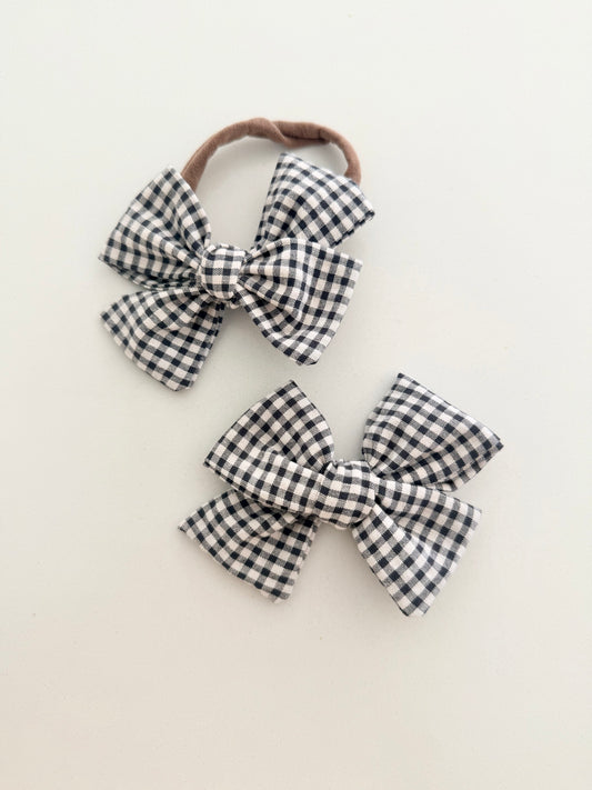 Two checkered bows on a beige background