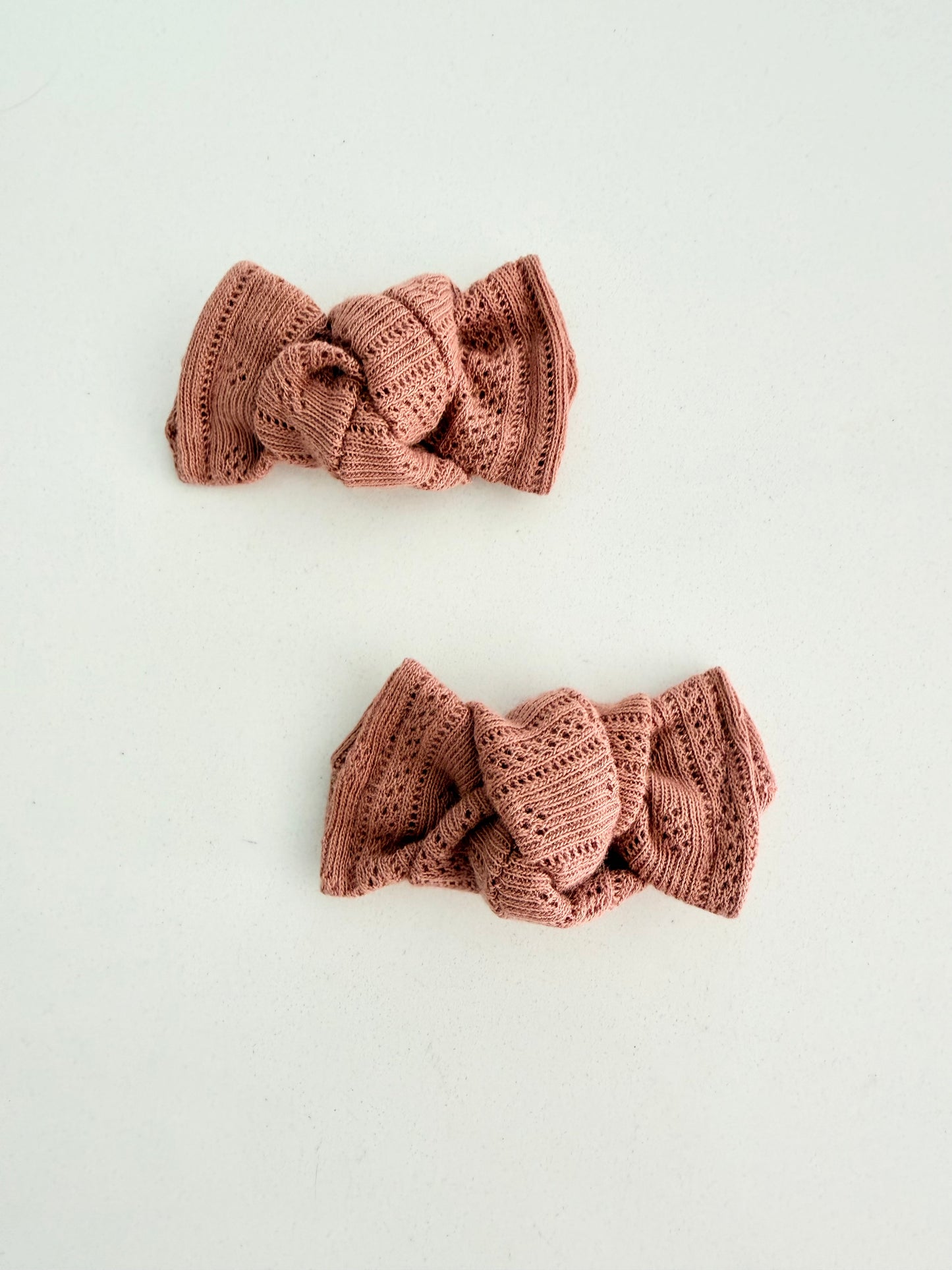 Dusty rose knit toddler pigtail bows, handmade in two sizes for a soft and cozy everyday look.