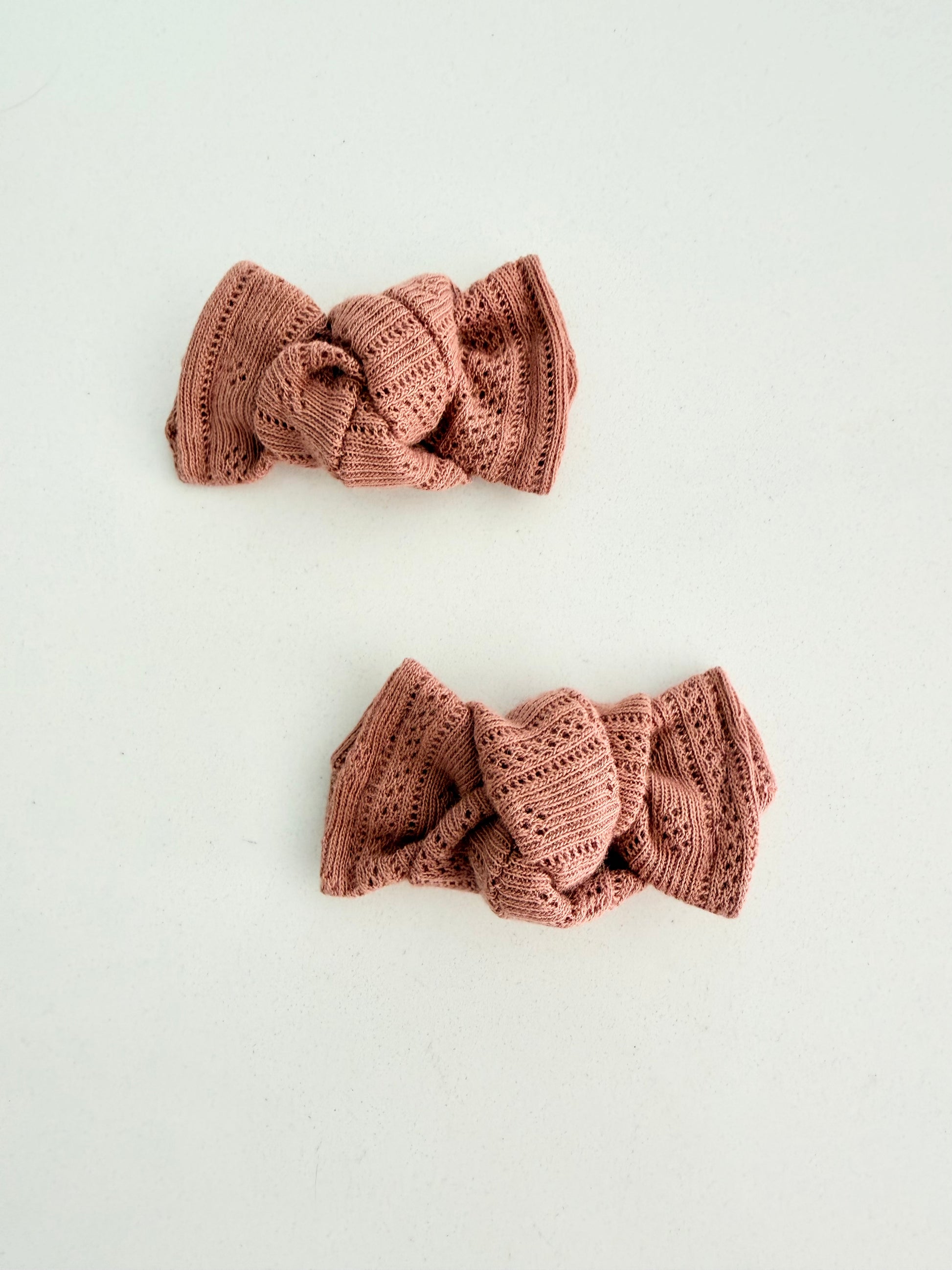 Dusty rose knit toddler pigtail bows, handmade in two sizes for a soft and cozy everyday look.
