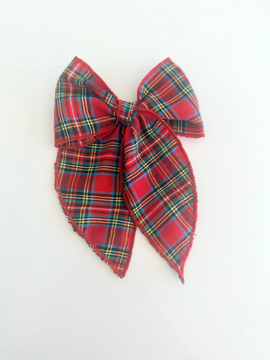 Red tartan plaid hair bow with long tails, shown in a mini and midi size option, available on alligator clip or soft nylon headband for babies and girls.