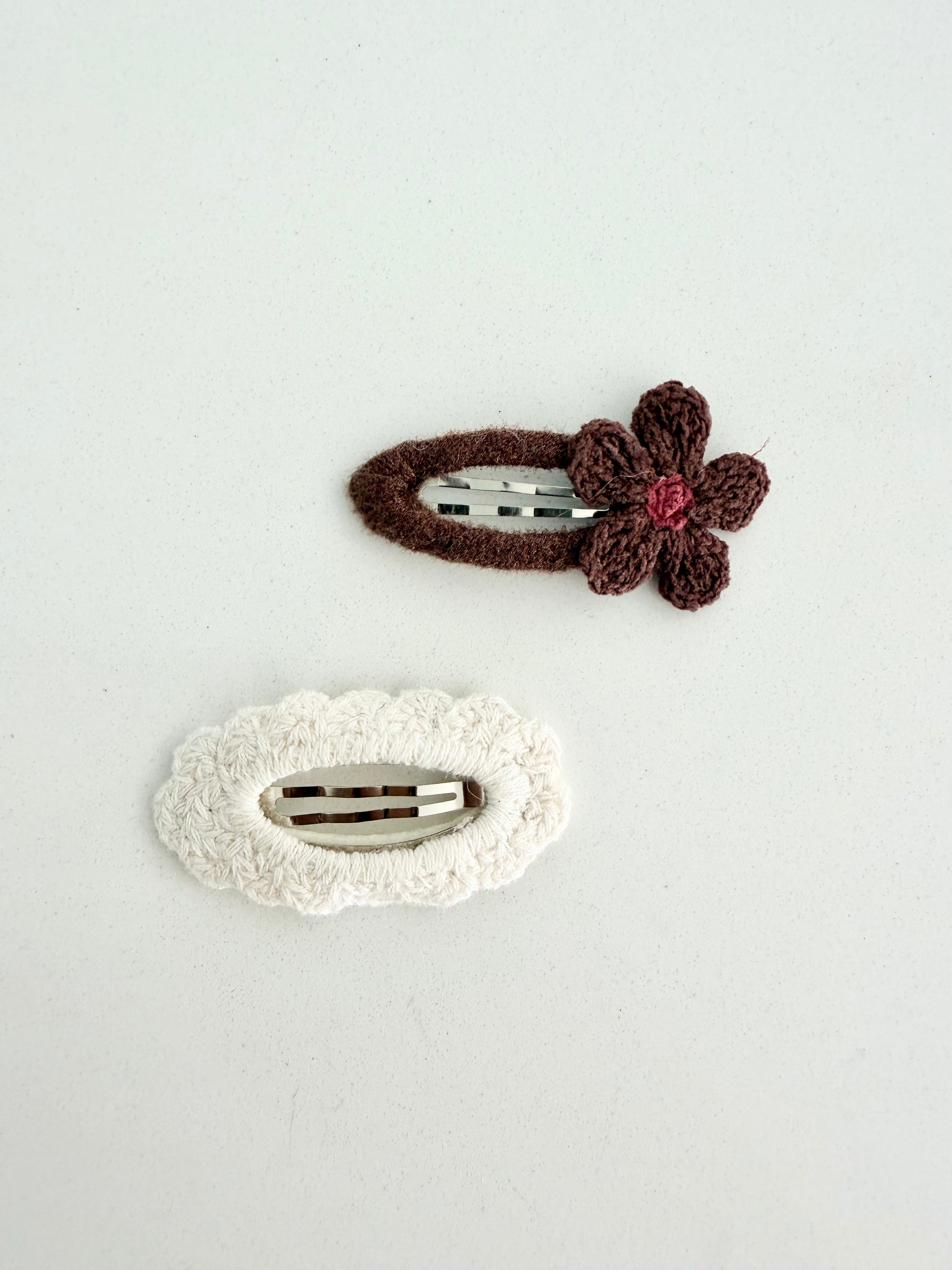 Handmade knit hair clips – brown flower barrette and cream textured clip displayed on Juju and Vivi backing card.