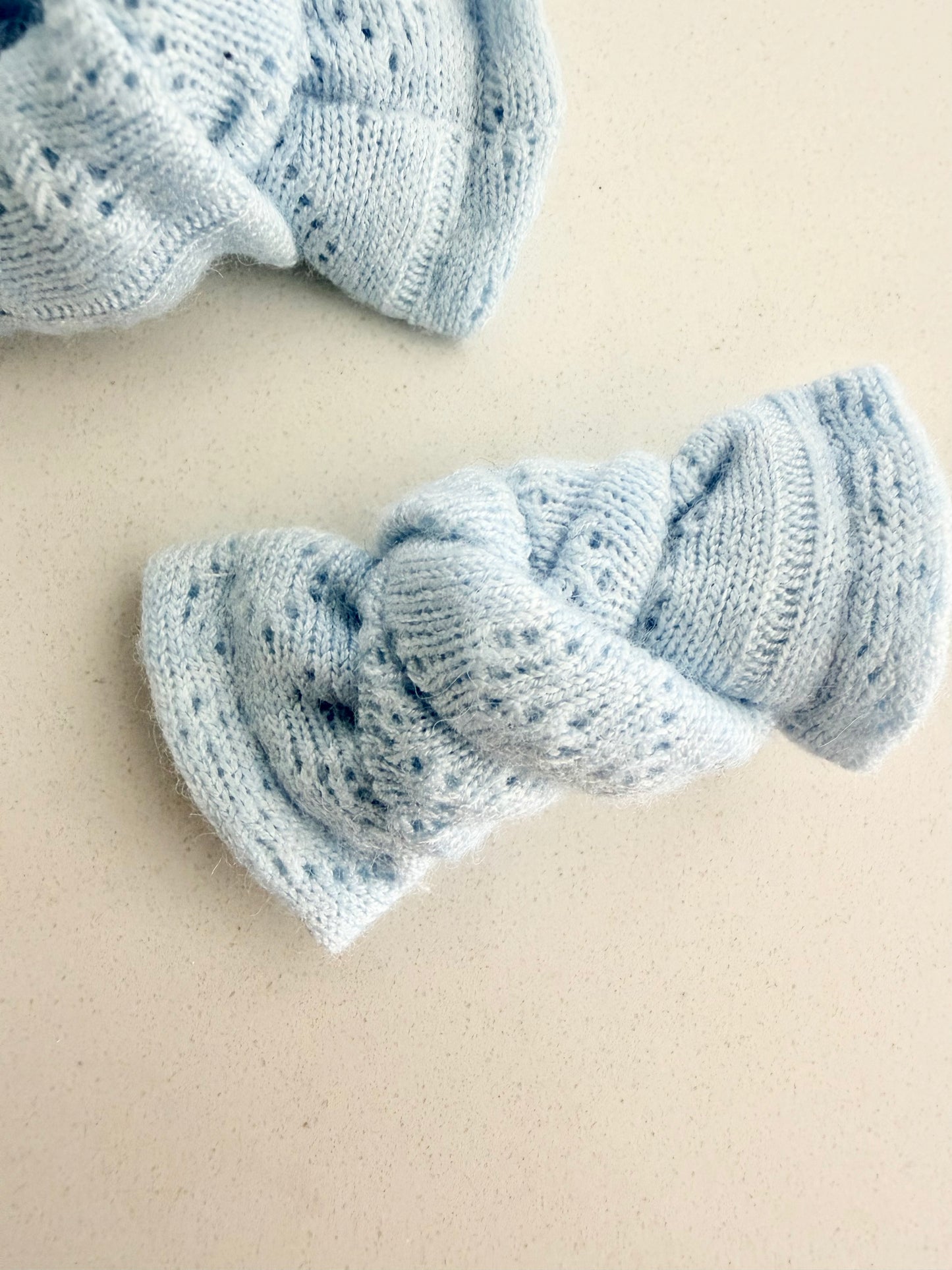 Baby blue knit pigtail bows for toddlers, handmade in two sizes for a soft and cozy everyday look.