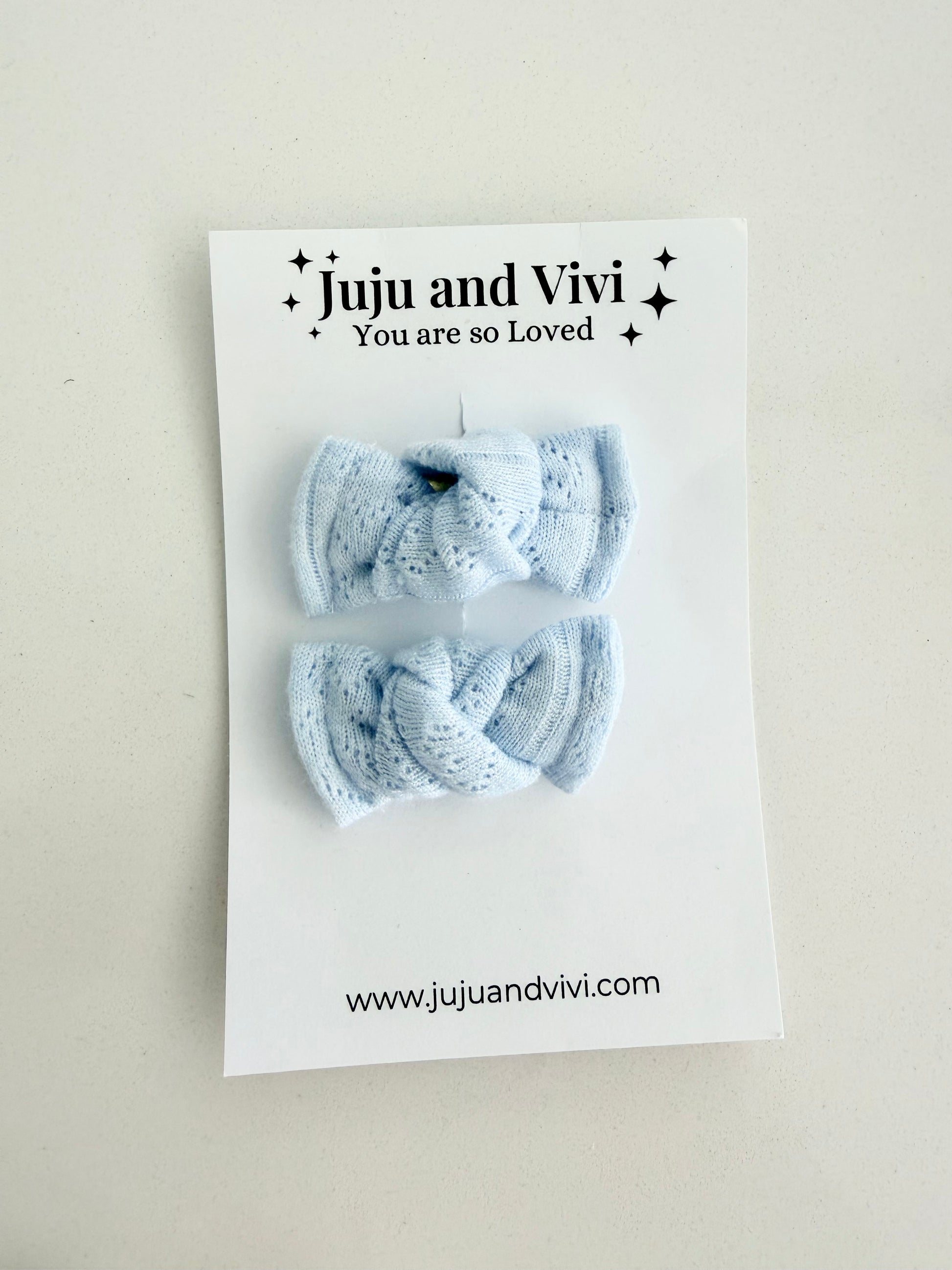Baby blue knit pigtail bows for toddlers, handmade in two sizes for a soft and cozy everyday look.