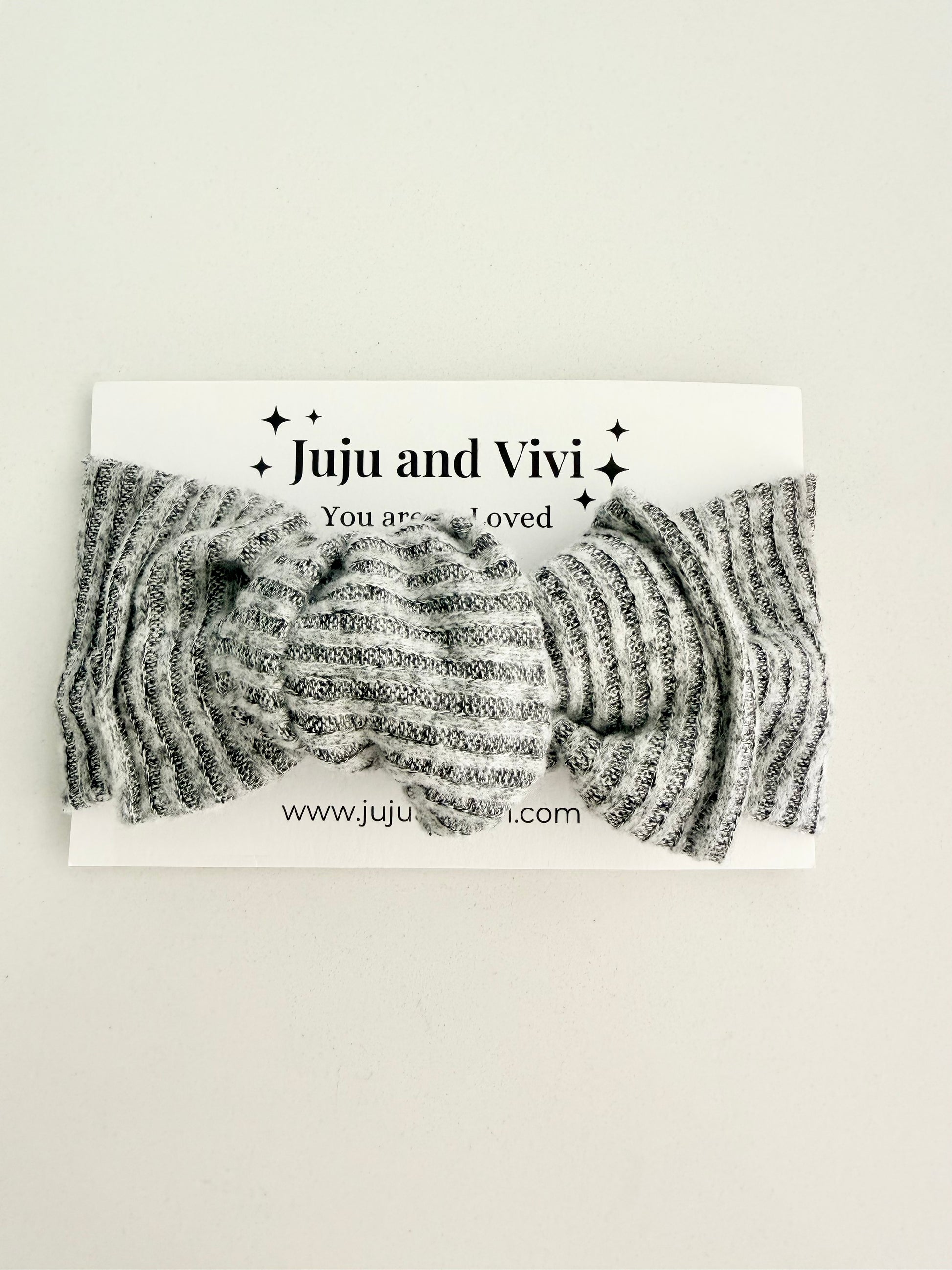 Grey jersey knit baby head wrap with subtle striped texture, stretchy fit, displayed on a white background.