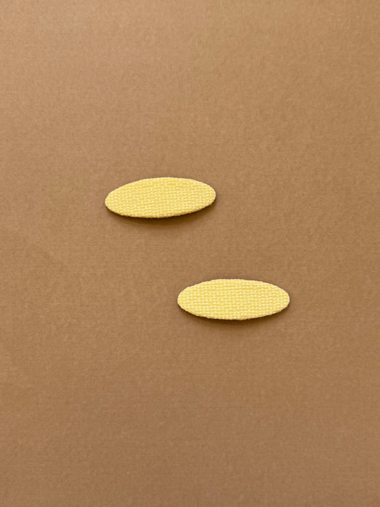 Oval yellow snap clip made with textured fabric