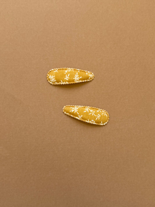Mustard yellow snap clip with scalloped edge and white leaf print