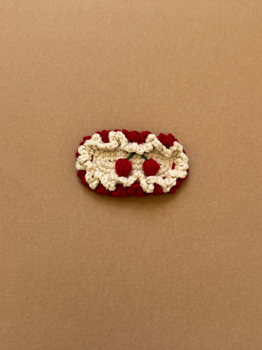 Hand-crocheted snap hair clip with cream scalloped edges and red embroidered cherries