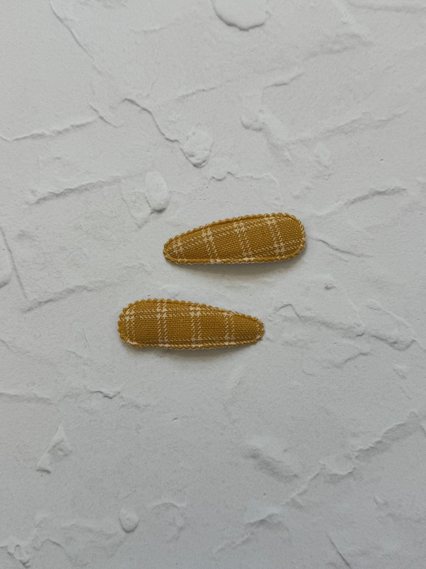 Snap clip with scalloped edge and large square grid pattern

