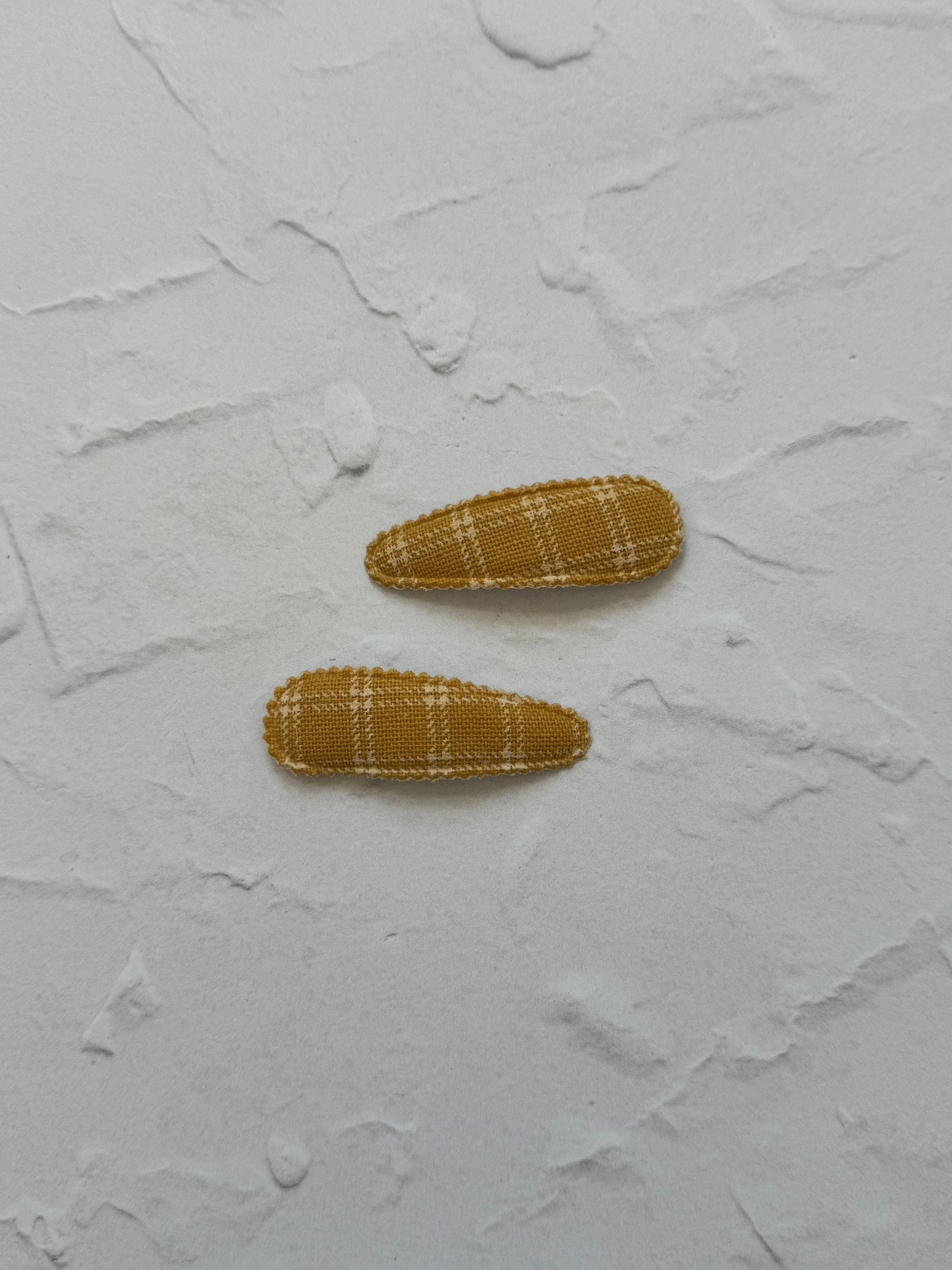 Snap clip with scalloped edge and large square grid pattern

