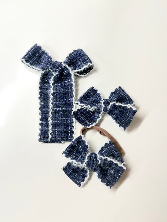 Navy textured handmade hair bow with white fuzzy stitched trim for babies, toddlers, and girls