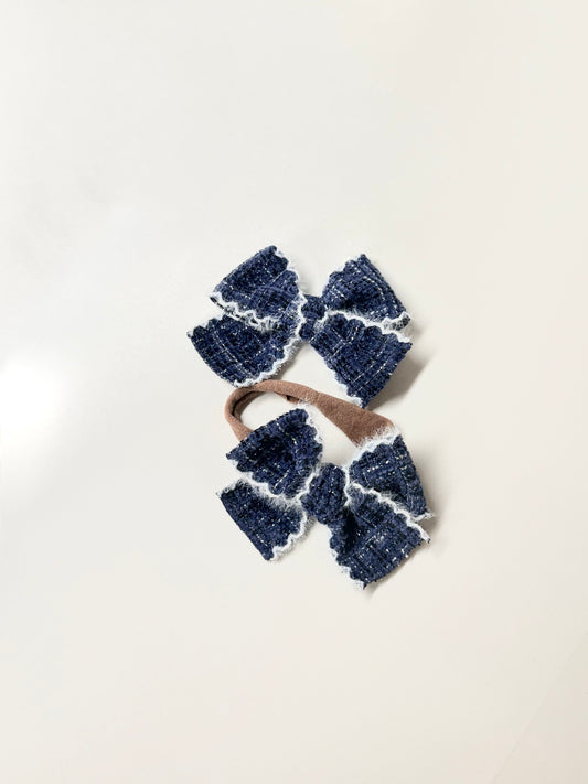 Navy textured handmade hair bow with white fuzzy stitched trim for babies, toddlers, and girls