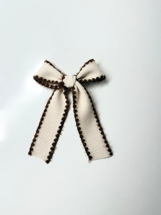 Cream knit hair bow with cocoa brown stitched trim, handmade accessory for babies, toddlers, and girls.