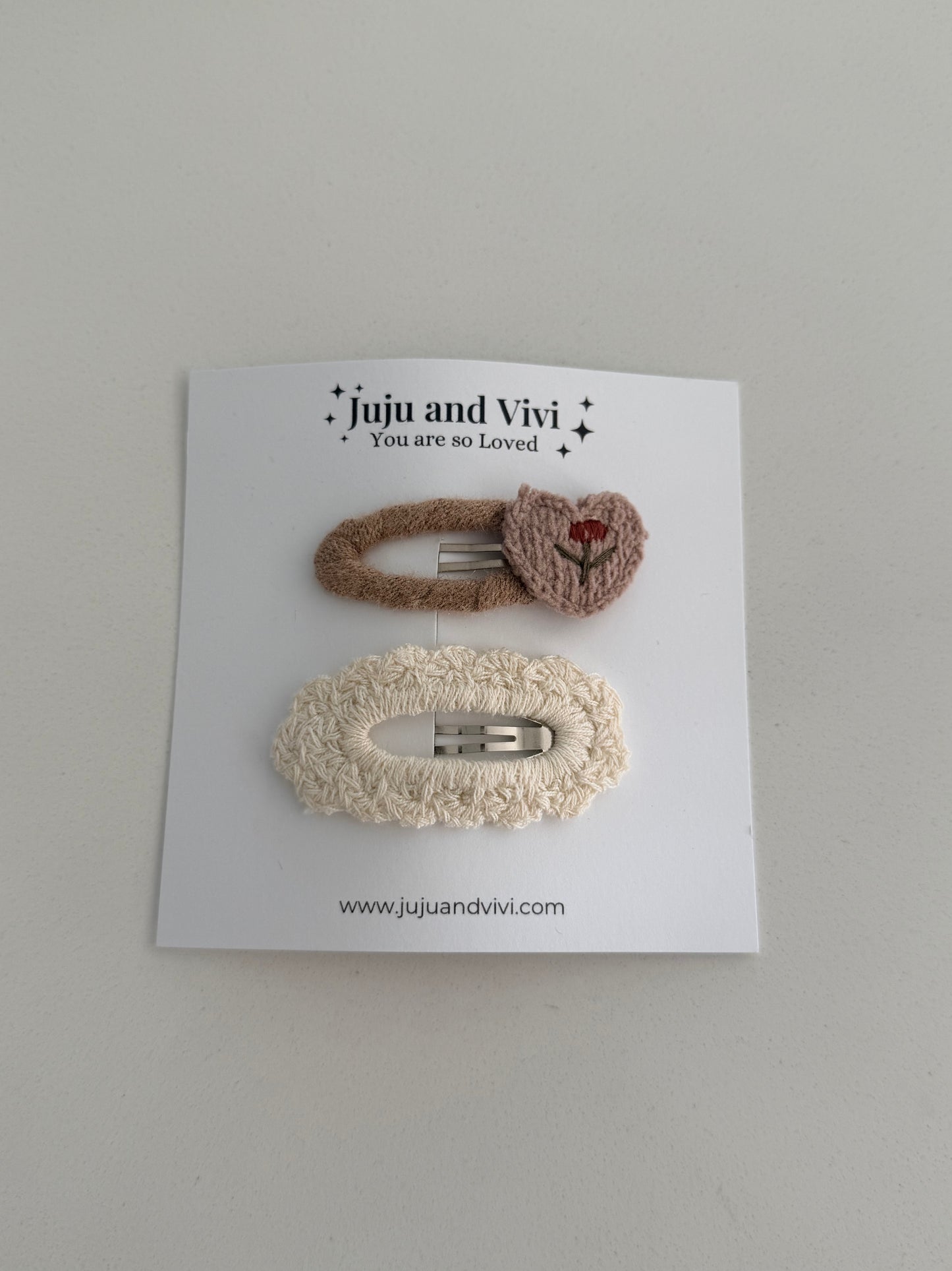 Soft knitted hair clips – beige embroidered flower barrette and cream textured clip on white background.