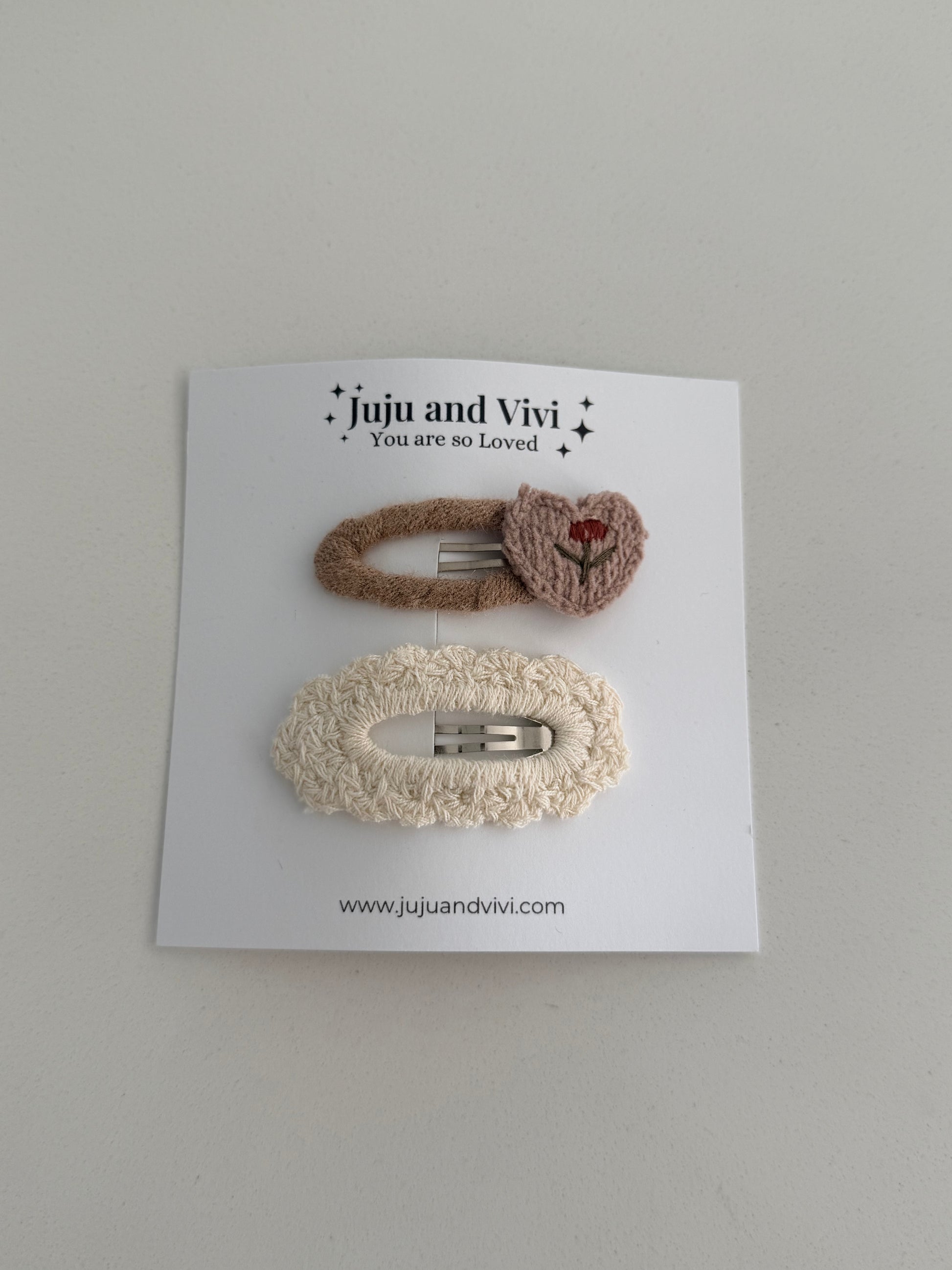 Soft knitted hair clips – beige embroidered flower barrette and cream textured clip on white background.