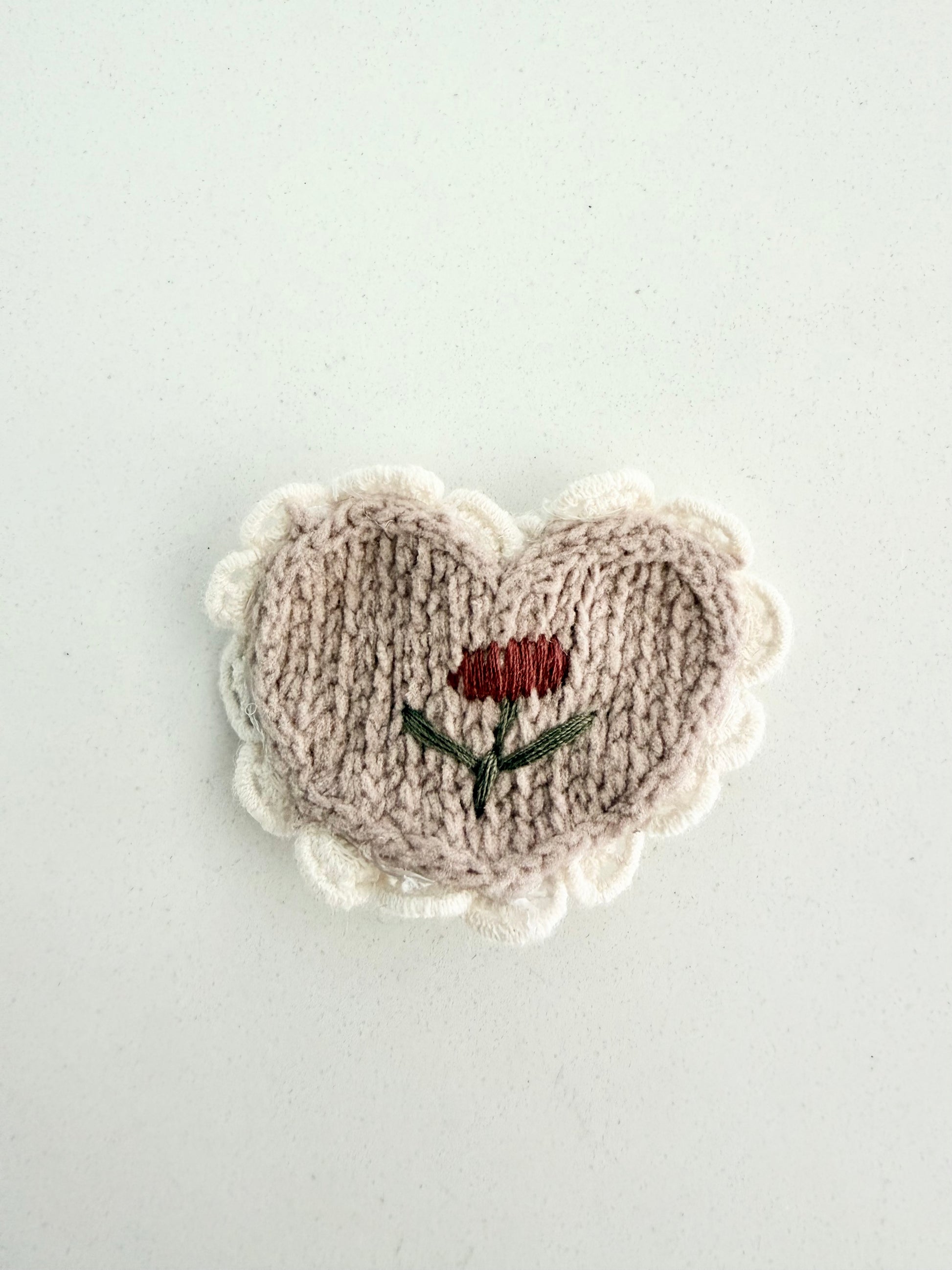 Handmade knit heart hair clip with embroidered red flower and cream scalloped edge